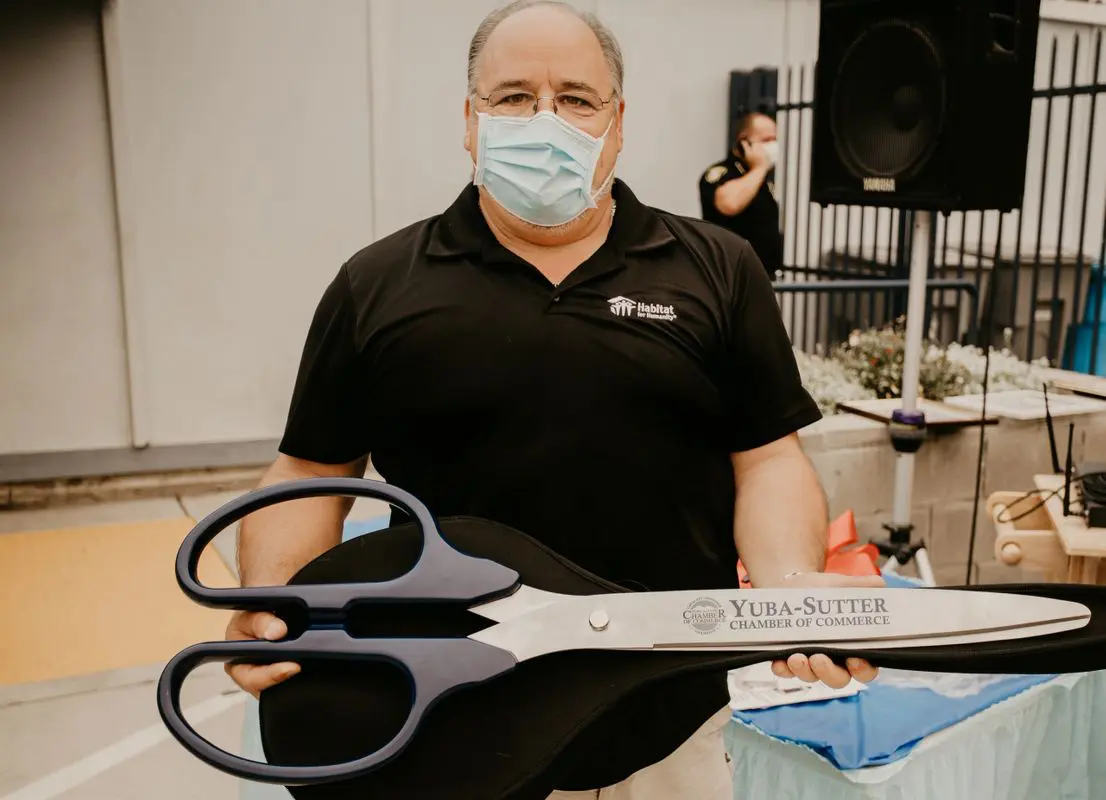 A man in a mask holding a pair of scissors.