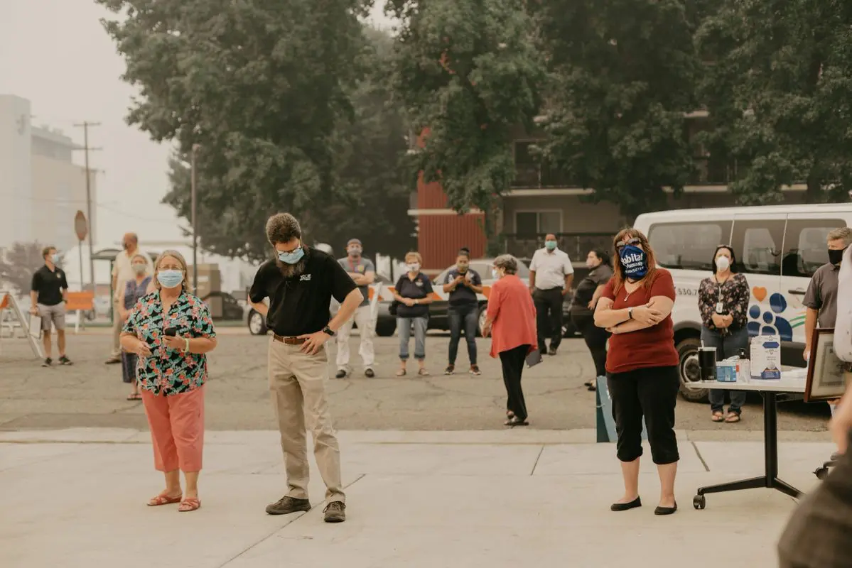 A group of people wearing face masks in front of a building.