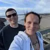 A man and woman taking a selfie on a boardwalk.