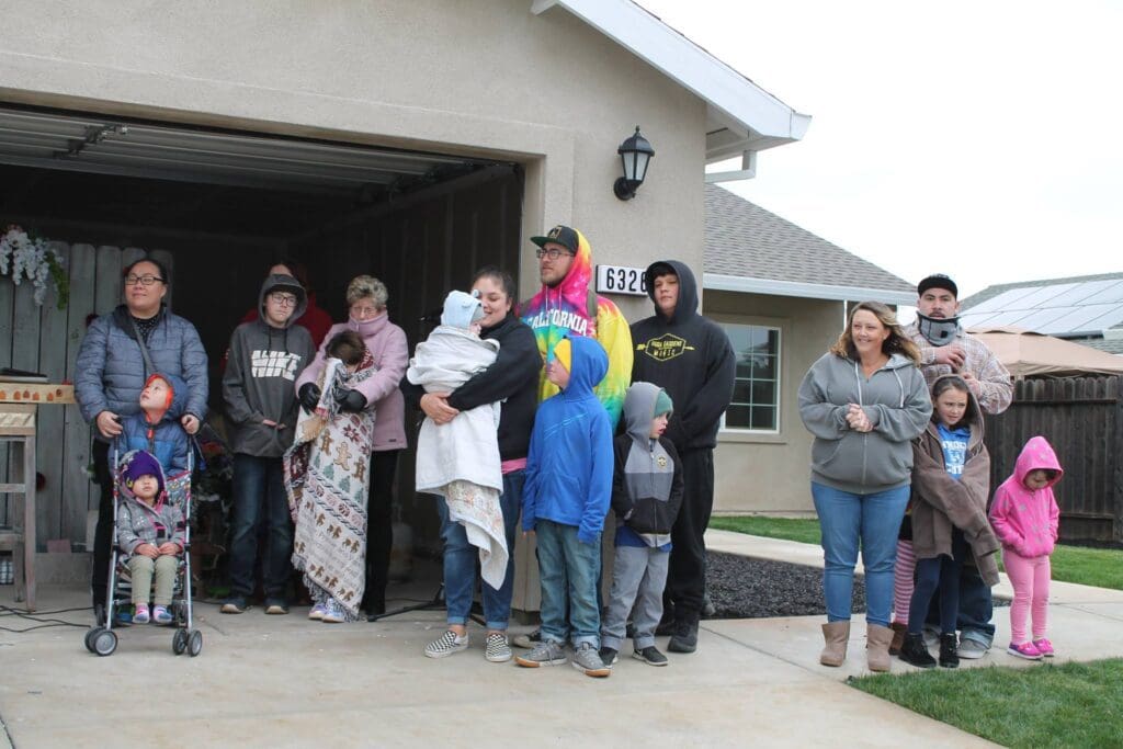 A group of people standing in front of a garage.