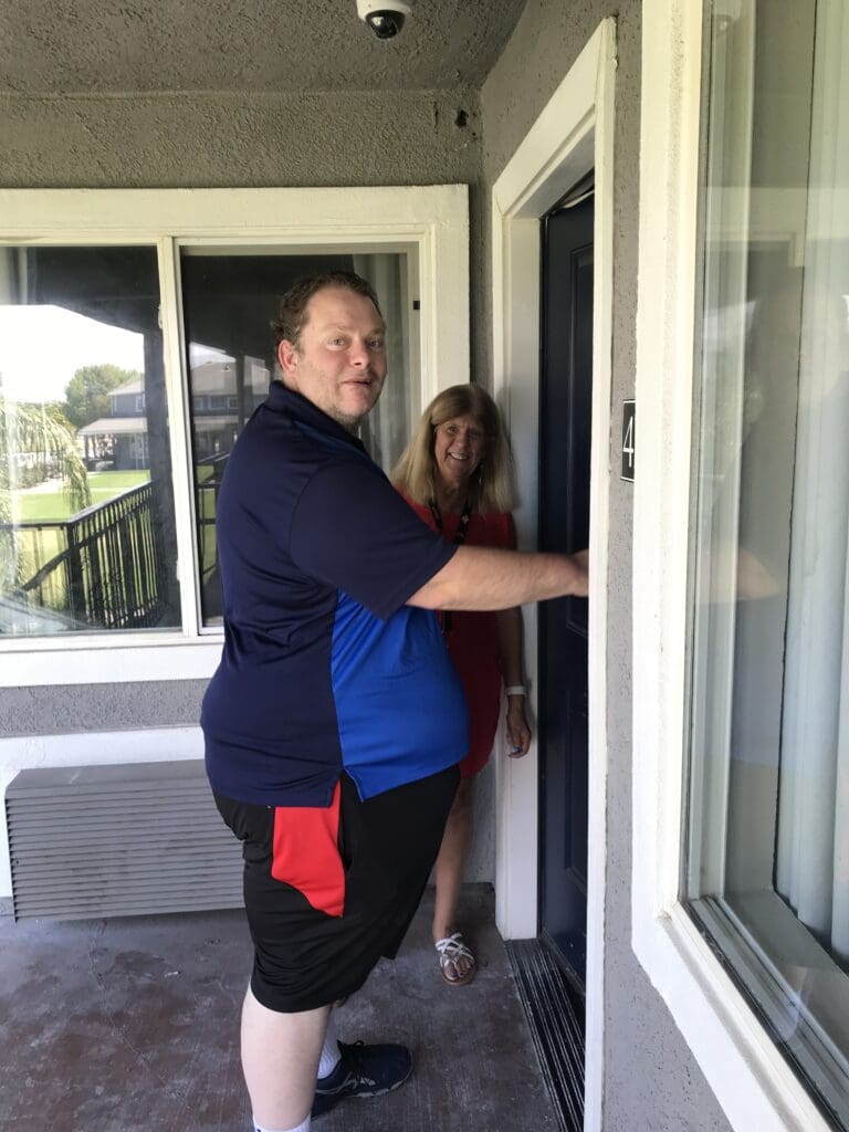 A man and a woman standing in front of a door.