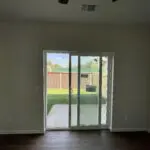 An empty living room with a sliding glass door.