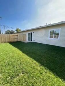 A backyard with grass and a fence.