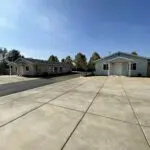 A parking lot with two homes and a driveway.