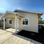 A home with a white siding and a driveway.