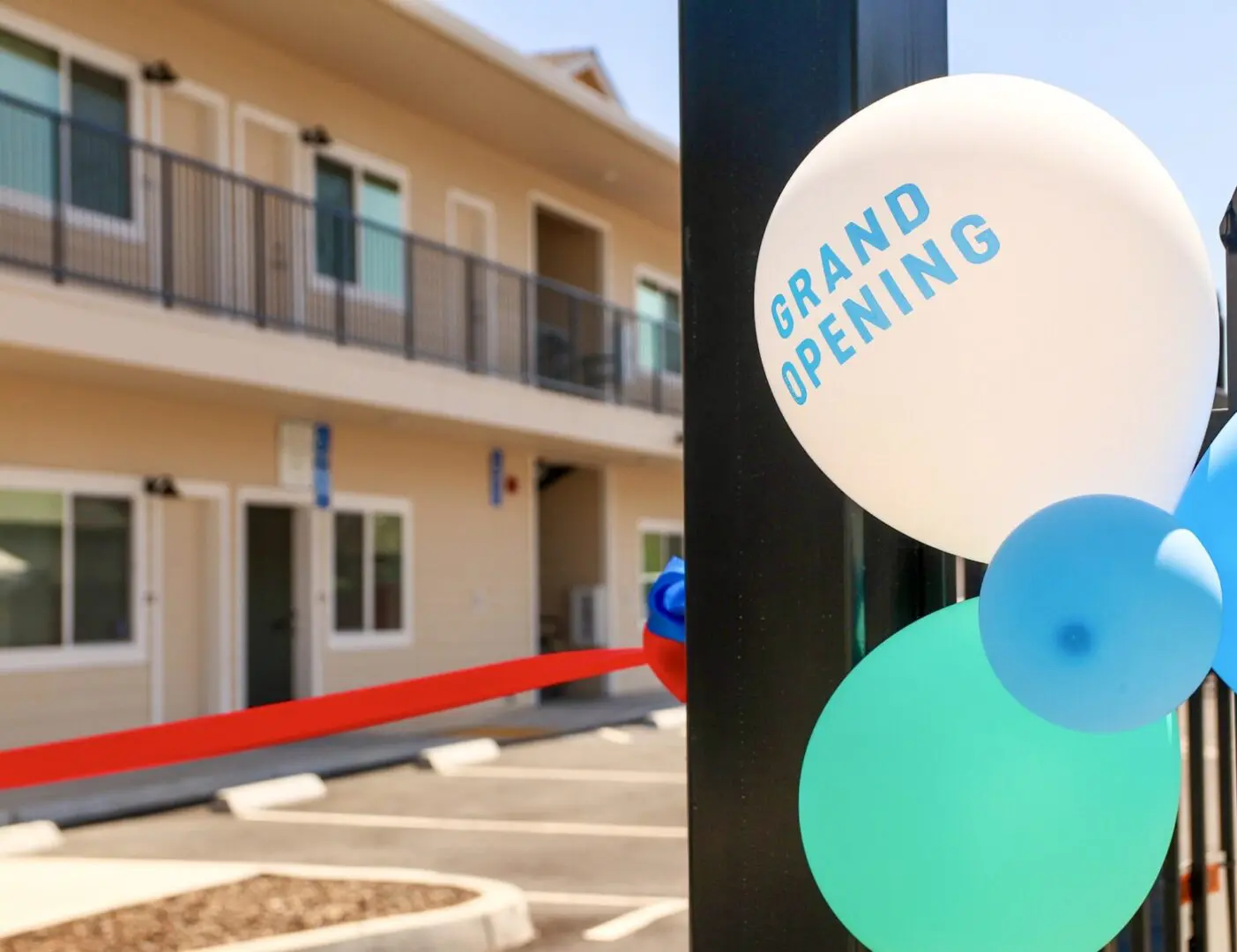 The grand opening of a new apartment complex with blue and white balloons.