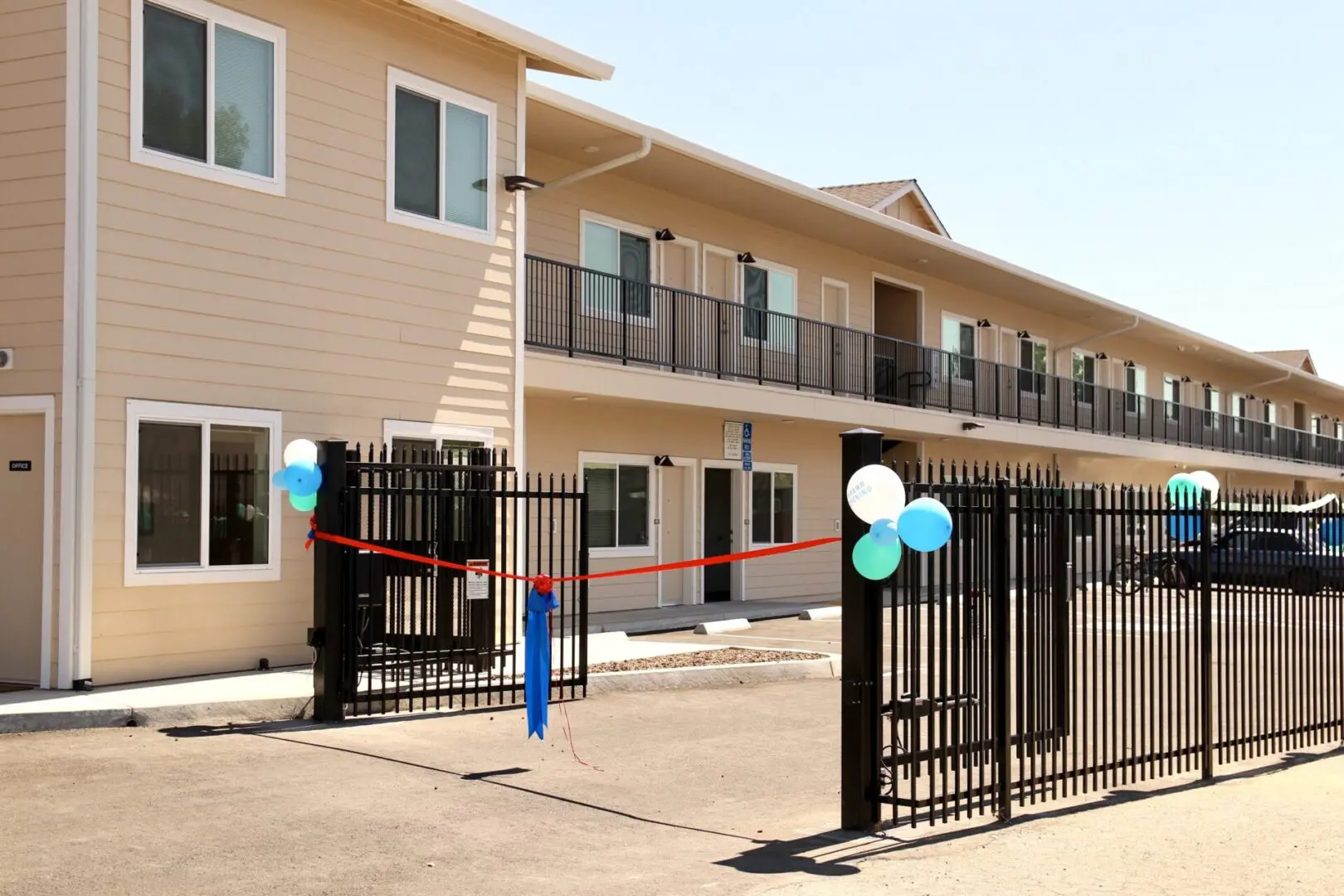 An apartment complex with a fence and balloons.