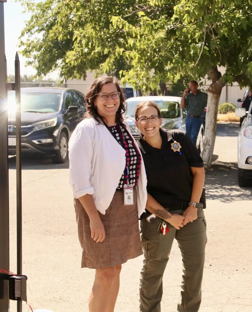 Two police officers standing next to each other in a parking lot.