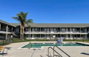 A swimming pool in front of a motel.