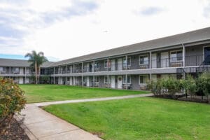 A large apartment complex with grass and trees.