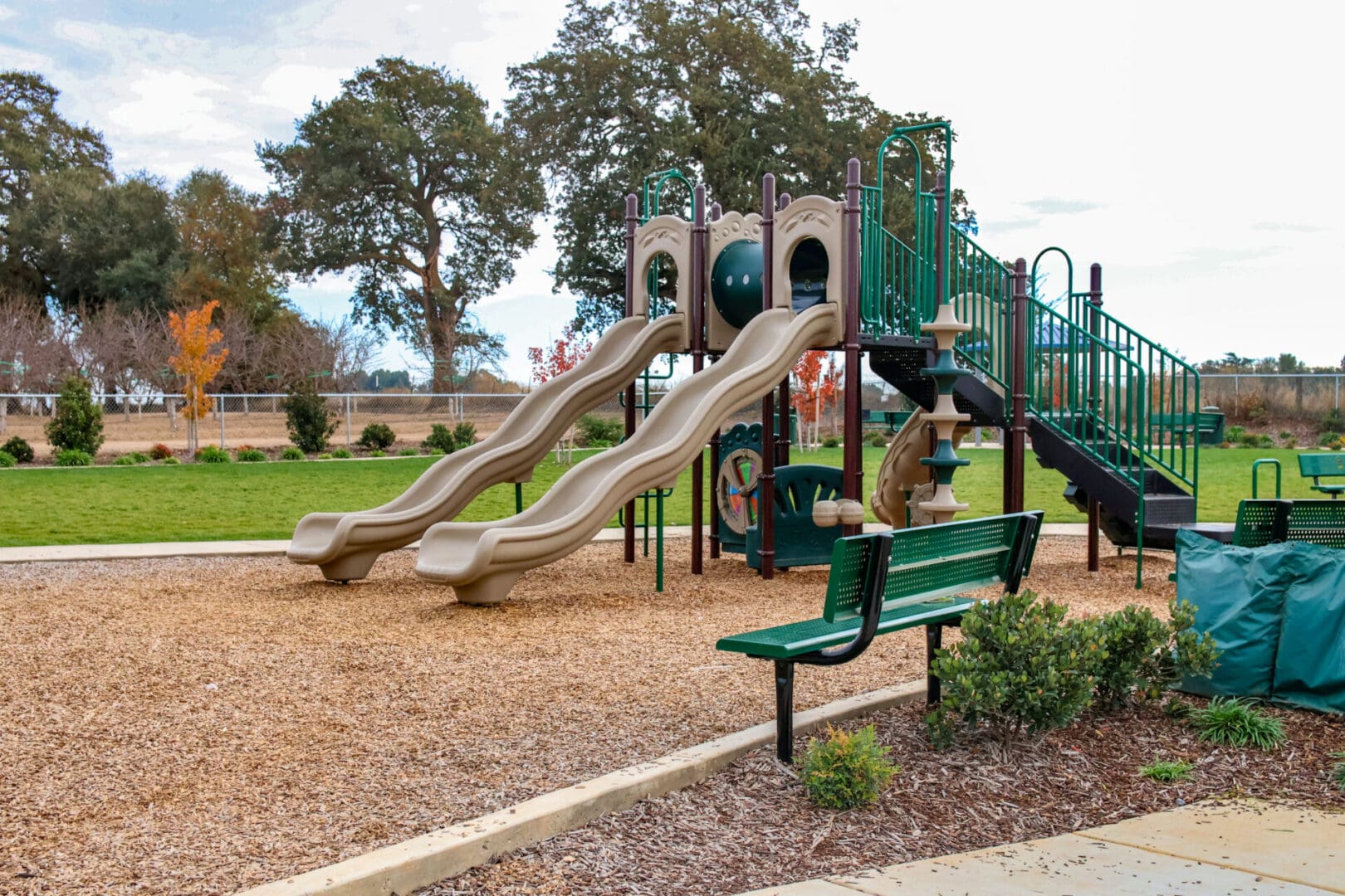 A playground with a slide and a bench.