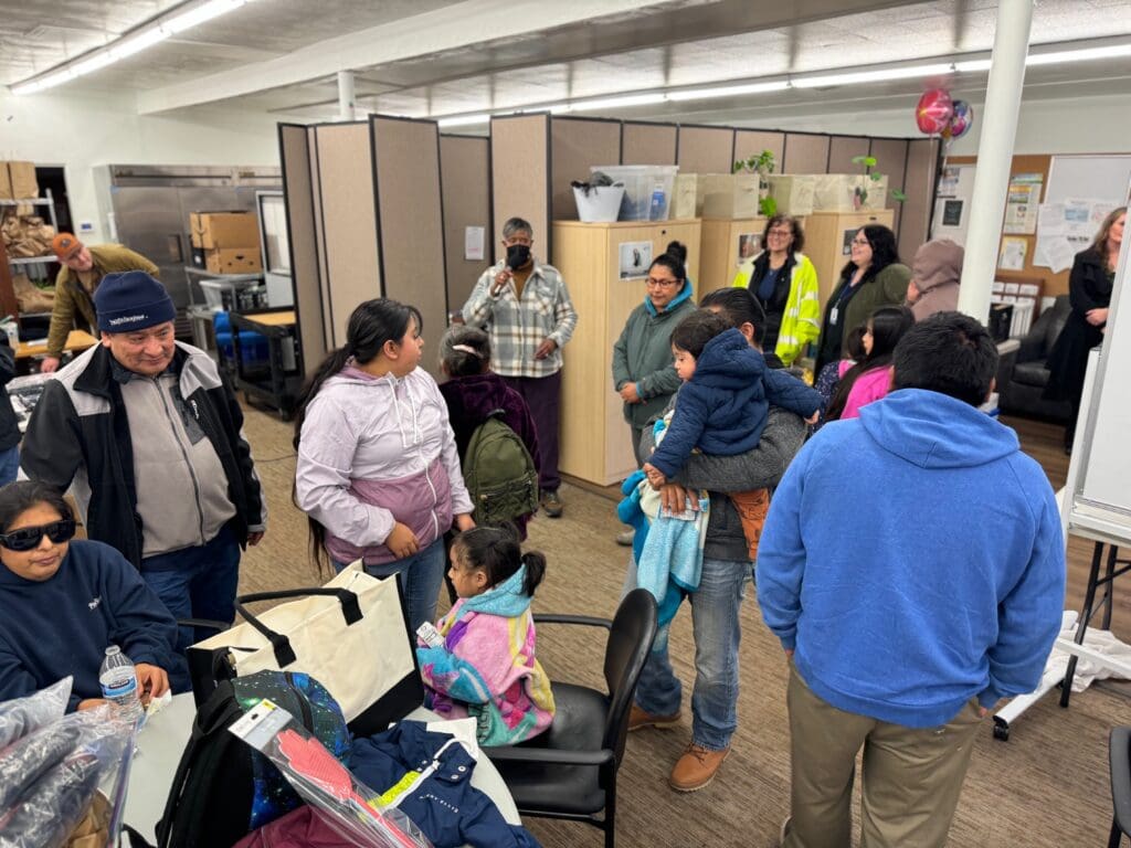 A group of people standing around in an office.