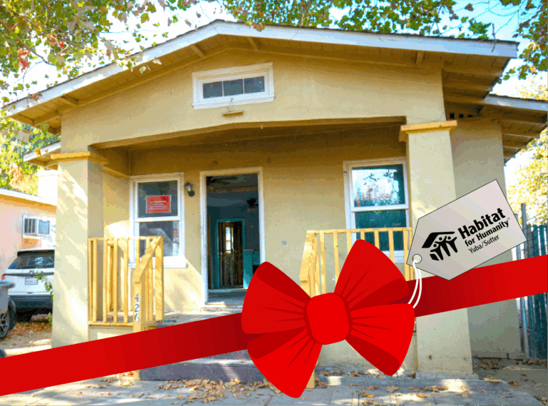 The Pine Street House with an illustrated bow and a tag with the Habitat for Humanity Yuba/Sutter logo on it