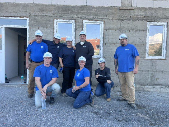 A team of Habitat for Humanity Yuba/Sutter Employees pose in front of the homes they are building